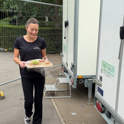 Person hand delivering charcuterie boards for a Cambridge catering event